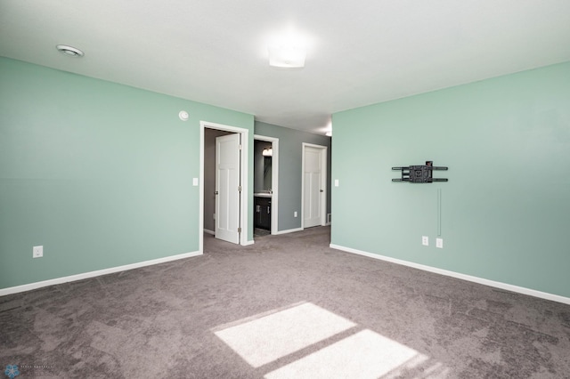 unfurnished room with carpet flooring and baseboards