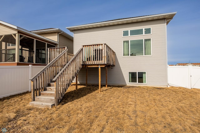 back of house with stairway, fence, and a sunroom