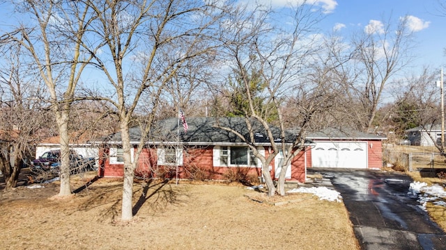 single story home featuring aphalt driveway and a garage