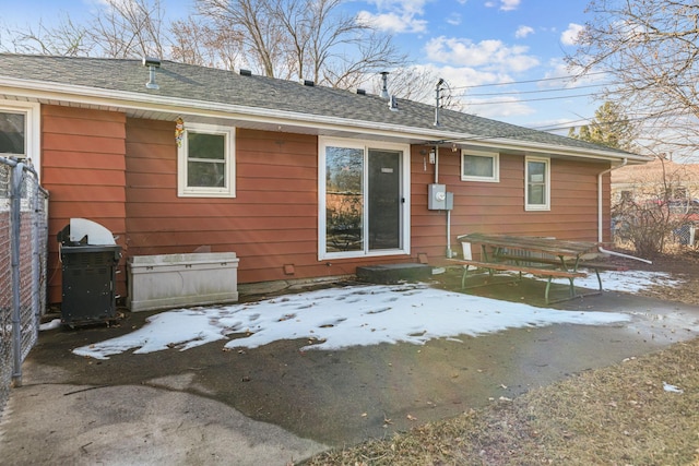 back of house featuring a patio and roof with shingles