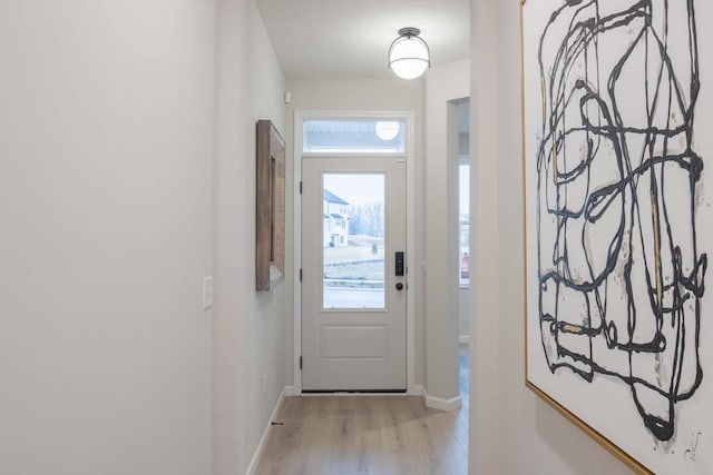 entryway featuring light wood-style floors and baseboards