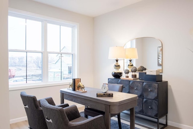 home office with wood finished floors, baseboards, and a wealth of natural light