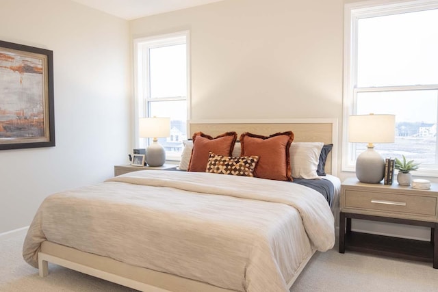 bedroom featuring light colored carpet and baseboards