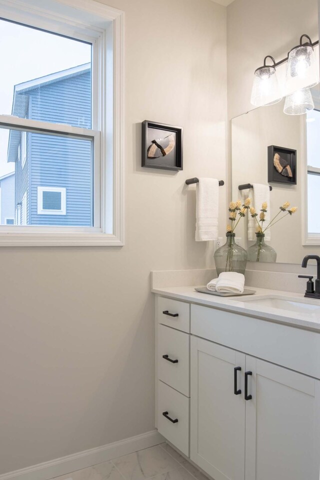 bathroom featuring vanity, baseboards, and marble finish floor