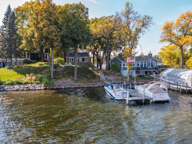 view of dock with a yard and a water view