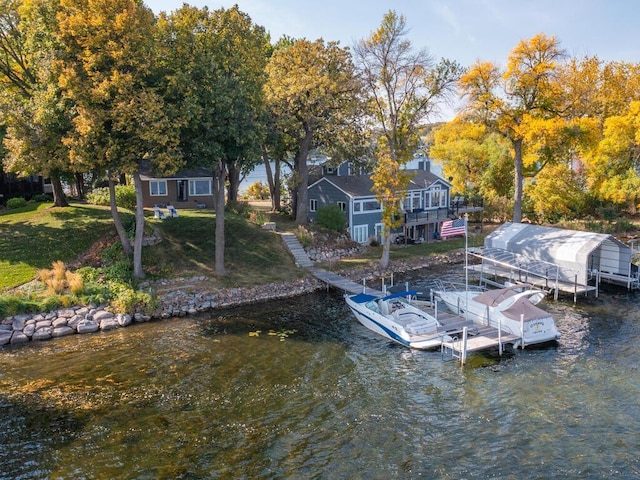 dock area with a deck with water view, a lawn, and stairs