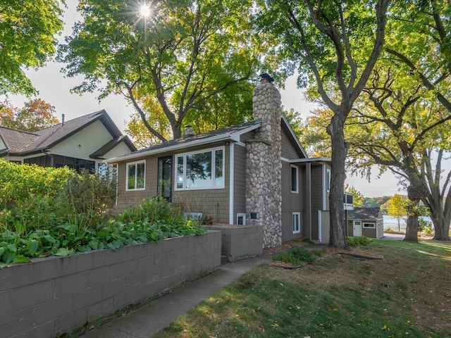 ranch-style house featuring a chimney and a front yard