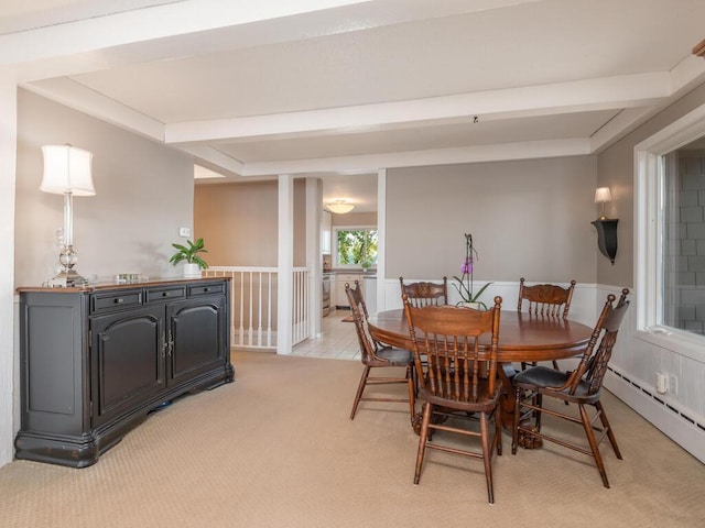 dining area with baseboard heating, light colored carpet, beamed ceiling, and a wainscoted wall