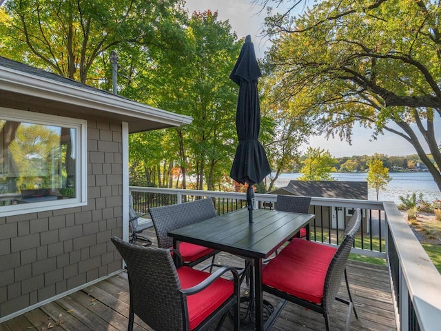 wooden deck featuring outdoor dining space and a water view