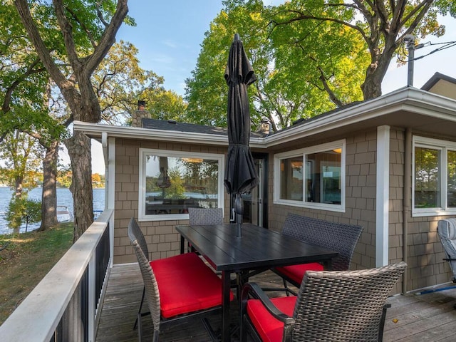 wooden deck featuring a water view and outdoor dining space