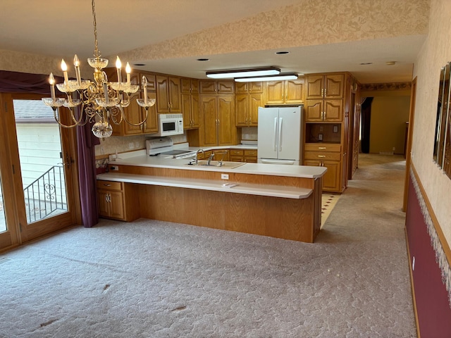 kitchen featuring light colored carpet, light countertops, a peninsula, brown cabinetry, and white appliances