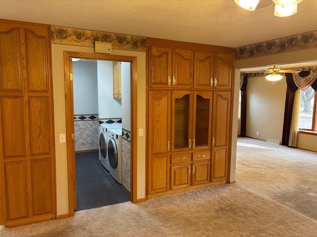 kitchen with visible vents, light colored carpet, brown cabinets, independent washer and dryer, and a textured ceiling