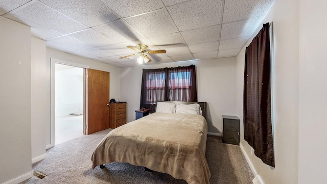 bedroom featuring visible vents, a ceiling fan, baseboards, carpet floors, and a paneled ceiling