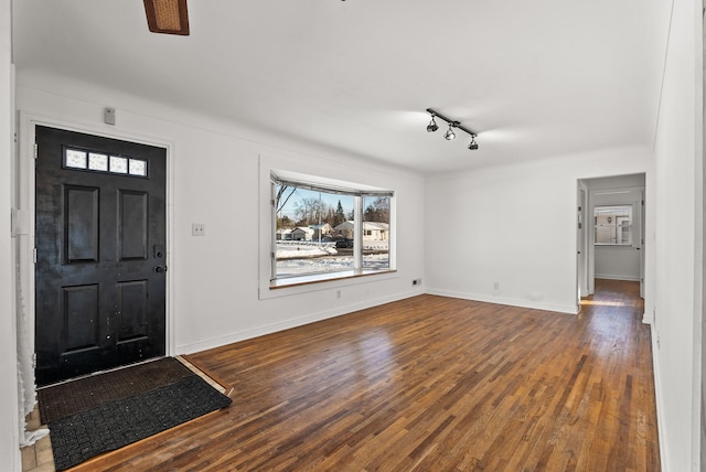 entryway featuring baseboards, wood-type flooring, and track lighting