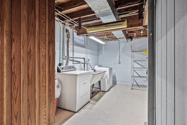 washroom with washer and clothes dryer, laundry area, light floors, and concrete block wall