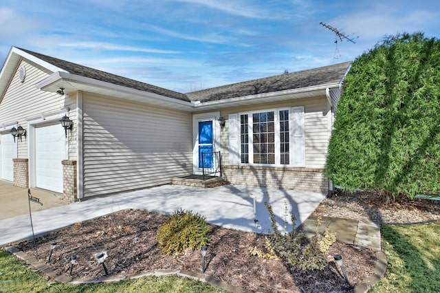 view of front of property featuring brick siding, concrete driveway, and an attached garage