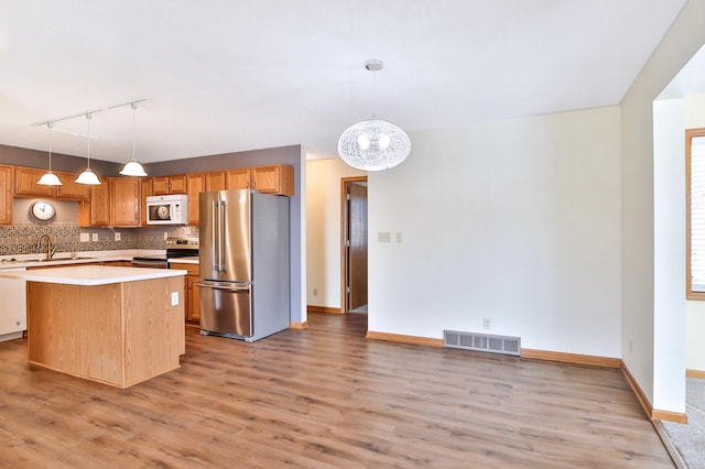 kitchen with visible vents, light countertops, light wood-style floors, appliances with stainless steel finishes, and backsplash