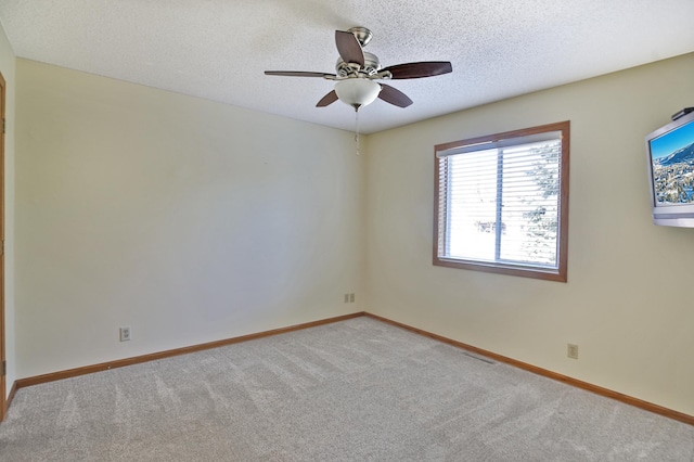 spare room featuring baseboards, visible vents, a textured ceiling, and carpet