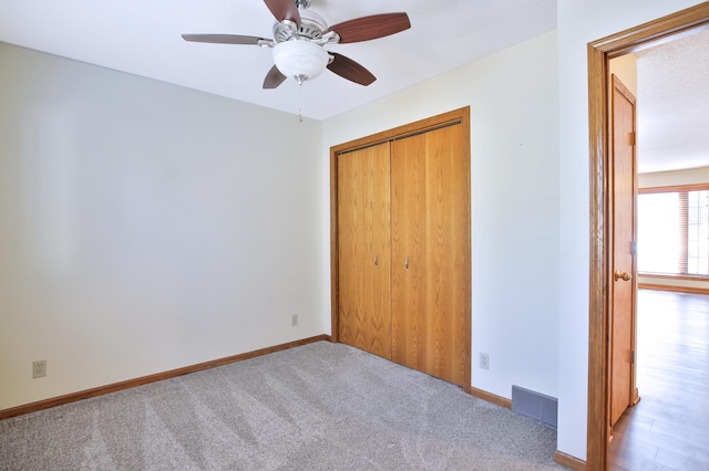 unfurnished bedroom featuring a closet, visible vents, baseboards, and carpet