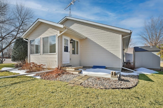 rear view of property featuring a lawn