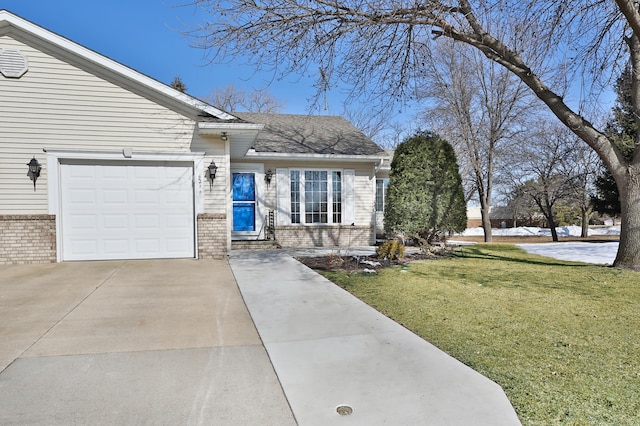 view of front facade with driveway, a front lawn, roof with shingles, an attached garage, and brick siding