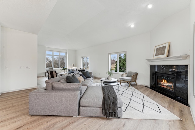 living room with a fireplace, vaulted ceiling, wood finished floors, baseboards, and recessed lighting
