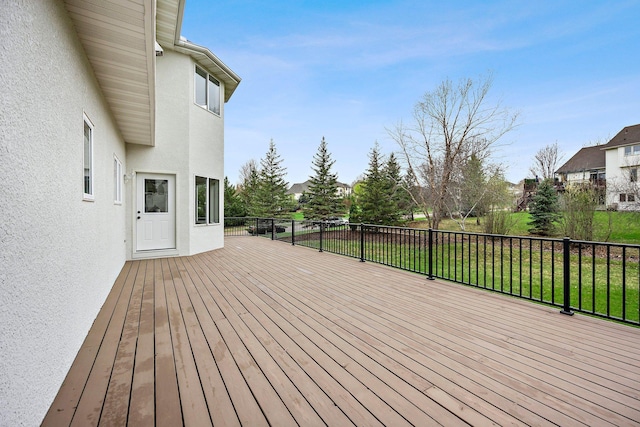 wooden deck featuring a yard and a residential view