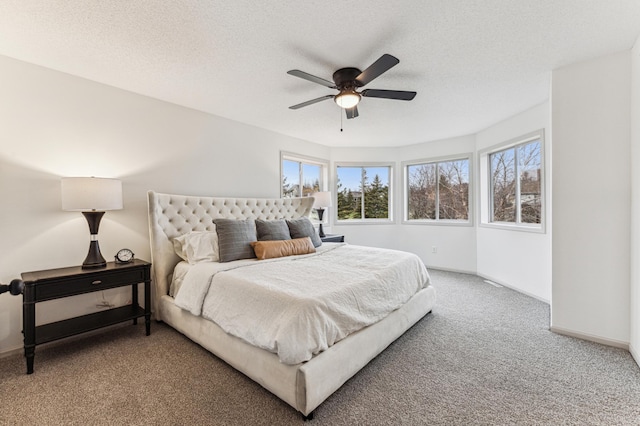 carpeted bedroom with baseboards, ceiling fan, and a textured ceiling