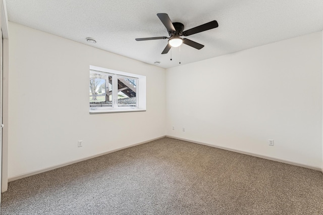 empty room featuring carpet floors, a ceiling fan, baseboards, and a textured ceiling