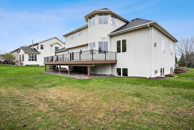 back of property featuring a lawn, stucco siding, and a deck