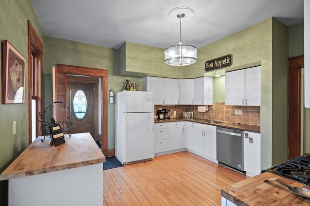 kitchen with a sink, wood counters, freestanding refrigerator, light wood finished floors, and dishwasher