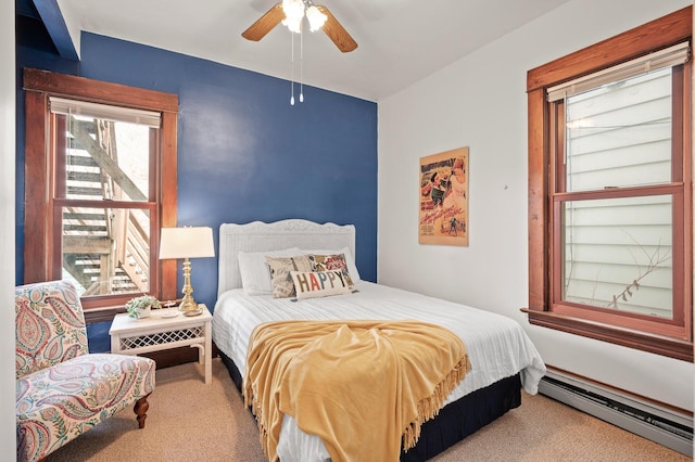 carpeted bedroom with baseboard heating and ceiling fan