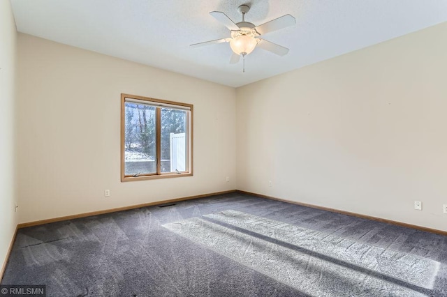 spare room with baseboards, carpet floors, visible vents, and ceiling fan