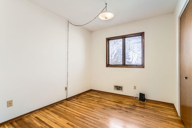 empty room with light wood finished floors and visible vents