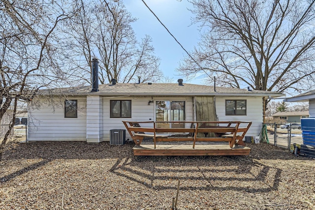 rear view of property featuring central air condition unit, a wooden deck, fence, and a gate