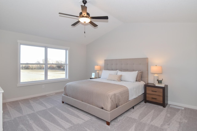 bedroom featuring ceiling fan, vaulted ceiling, baseboards, and light carpet