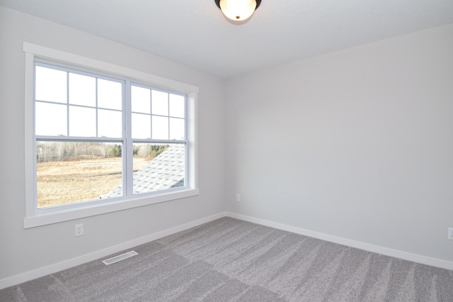 carpeted spare room with baseboards and visible vents