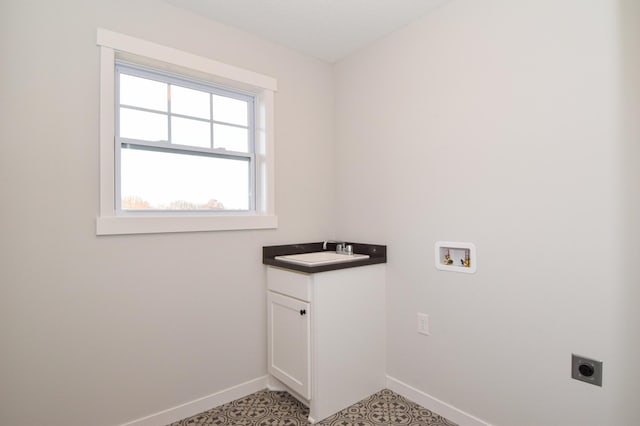 washroom featuring hookup for a washing machine, baseboards, hookup for an electric dryer, cabinet space, and a sink