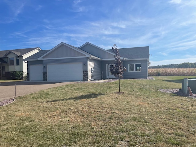 ranch-style house with stone siding, a garage, driveway, and a front lawn