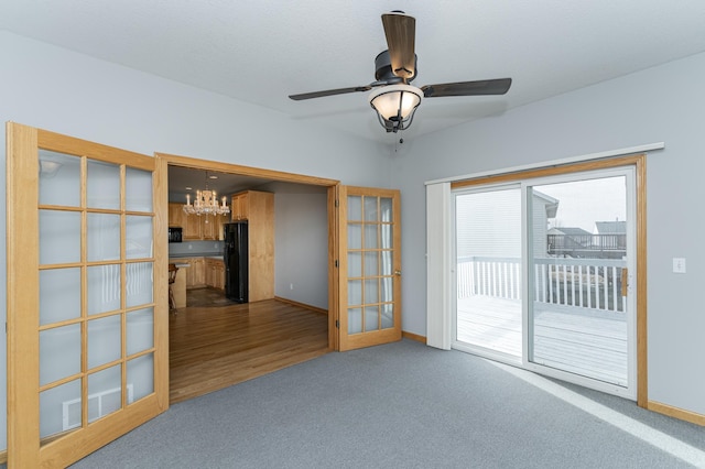 empty room with visible vents, baseboards, carpet, ceiling fan with notable chandelier, and french doors