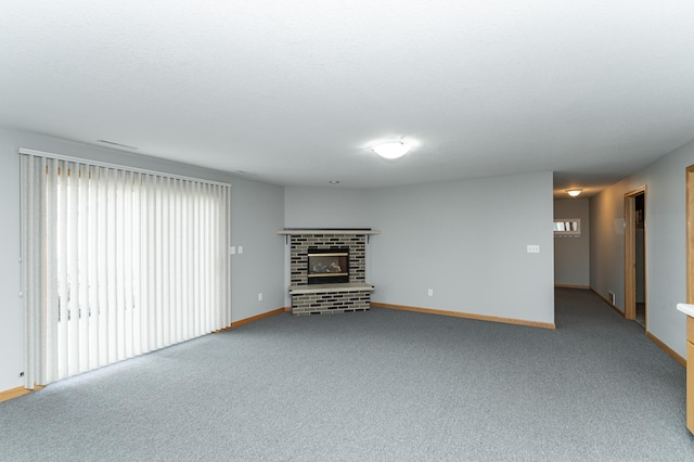 unfurnished living room with plenty of natural light, a fireplace, baseboards, and carpet