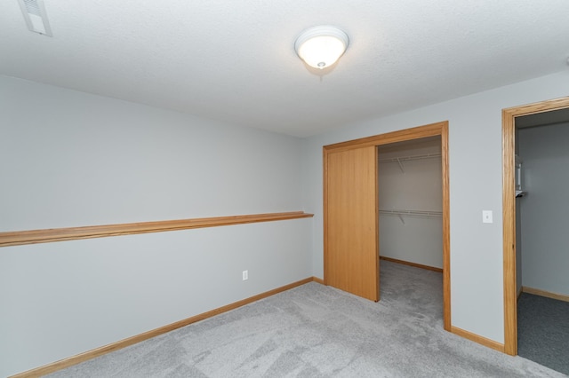 unfurnished bedroom featuring a closet, visible vents, baseboards, and carpet