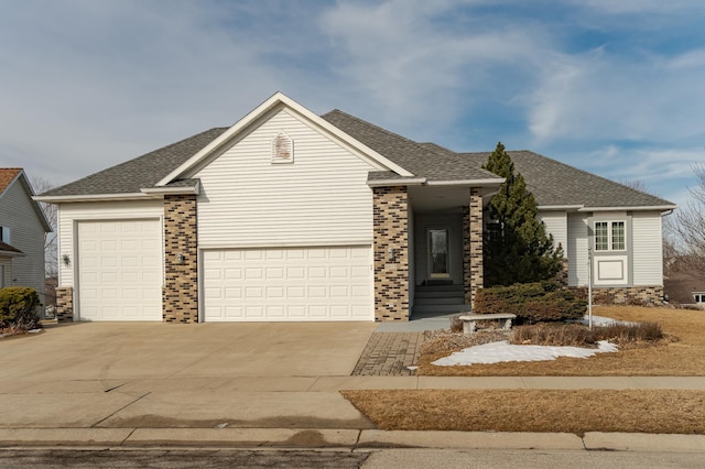 view of front of home featuring an attached garage, brick siding, driveway, and a shingled roof