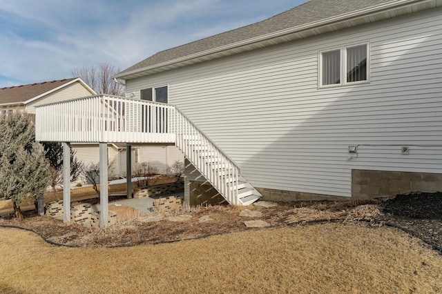 rear view of property with stairway, a wooden deck, and a shingled roof