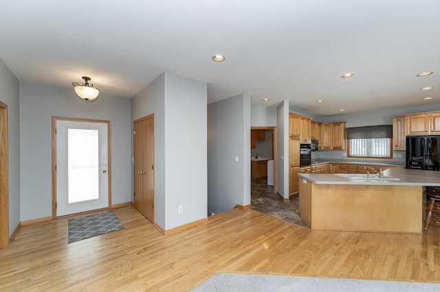 kitchen with plenty of natural light, black fridge, and light wood-type flooring