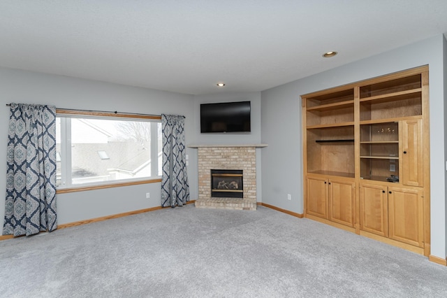 unfurnished living room with recessed lighting, a brick fireplace, baseboards, and carpet floors