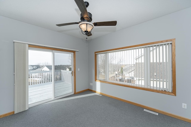 empty room with visible vents, a healthy amount of sunlight, baseboards, and carpet floors