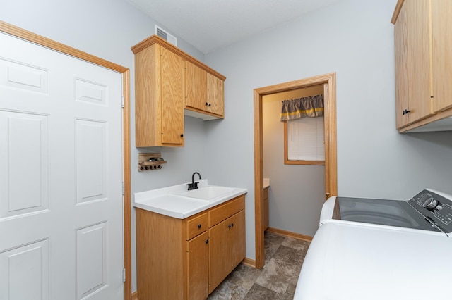 washroom with washer and dryer, cabinet space, baseboards, and a sink