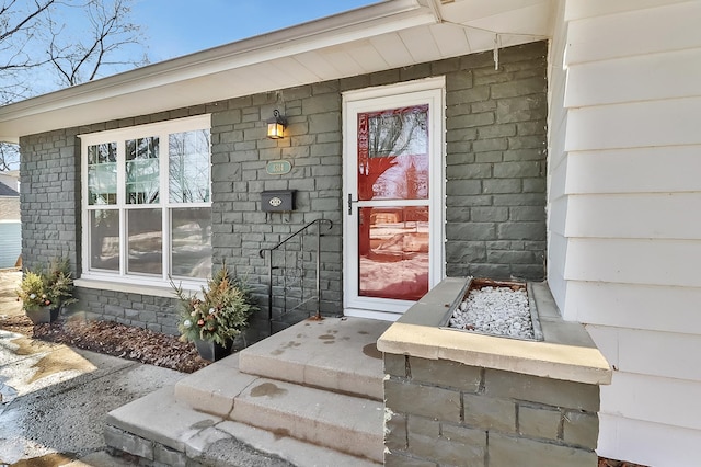 view of exterior entry with brick siding