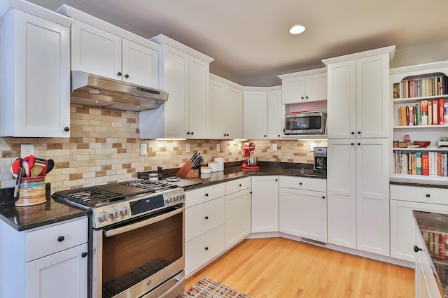 kitchen featuring white cabinetry, light wood-type flooring, under cabinet range hood, and stainless steel appliances